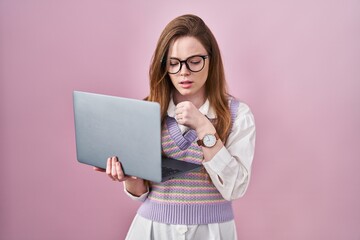 Naklejka premium Young caucasian woman working using computer laptop feeling unwell and coughing as symptom for cold or bronchitis. health care concept.