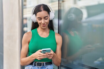 Young beautiful hispanic woman smiling confident watching video on smartphone at street
