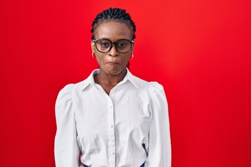 Obraz premium African woman with braids standing over red background depressed and worry for distress, crying angry and afraid. sad expression.