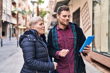 Mother and son smiling confident having video call at street