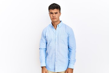 Fototapeta premium Young hispanic man wearing business shirt standing over isolated background skeptic and nervous, frowning upset because of problem. negative person.
