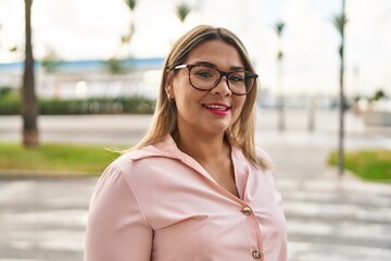 Fototapeta premium Young hispanic woman smiling confident standing at street
