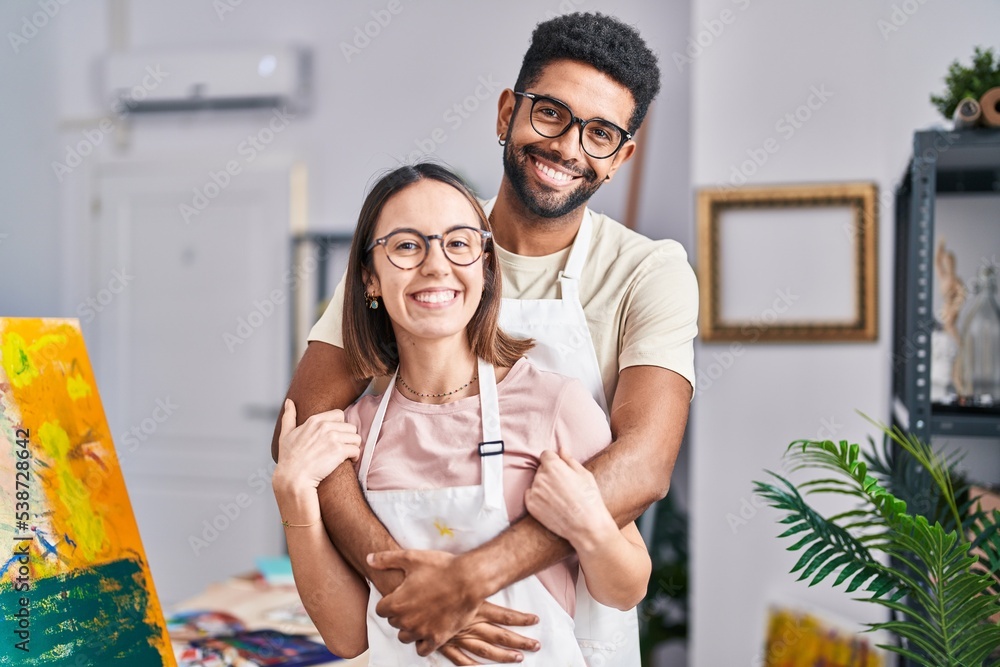 Poster Man and woman artists smiling confident hugging each other at art studio