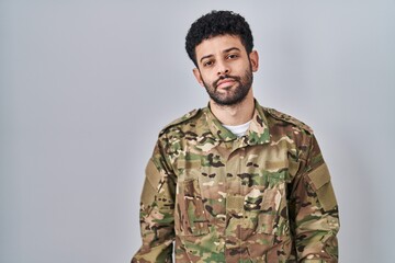 Arab man wearing camouflage army uniform looking sleepy and tired, exhausted for fatigue and...