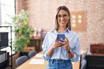 Young beautiful hispanic woman business worker smiling confident using smartphone at office