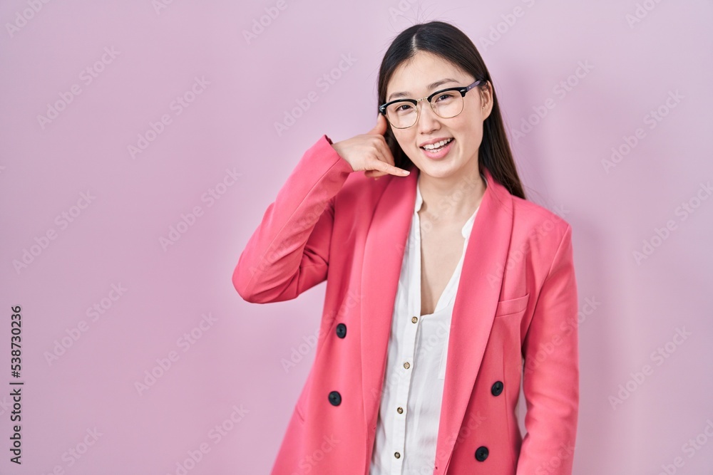 Sticker Chinese business young woman wearing glasses smiling doing phone gesture with hand and fingers like talking on the telephone. communicating concepts.