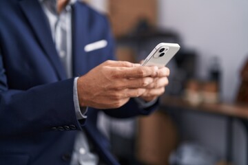 Young hispanic man business worker using smartphone at office