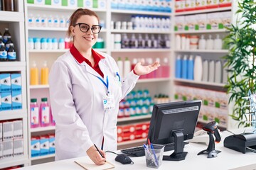 Young beautiful plus size woman pharmacist writing on notebook at pharmacy