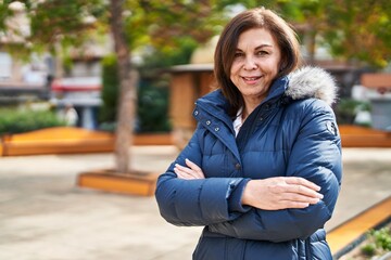 Obraz premium Middle age woman standing with arms crossed gesture at park