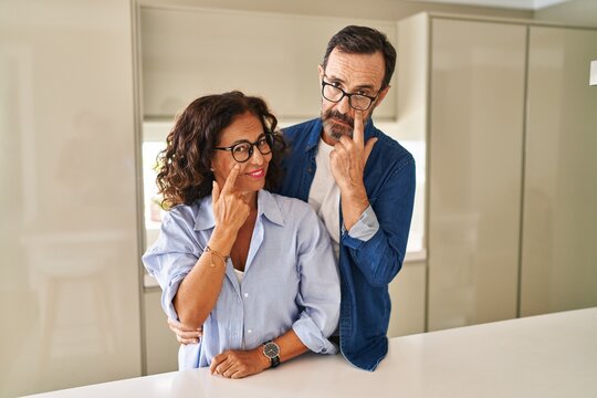 Middle Age Couple Standing Together Pointing To The Eye Watching You Gesture, Suspicious Expression