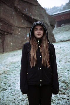 Girl with coat in the mountains while it snows