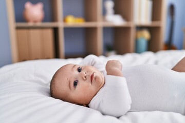 Adorable baby relaxed lying on bed at bedroom