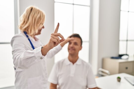 Middle Age Man And Woman Doctor And Patient Examining Vision Having Medical Consultation At Clinic