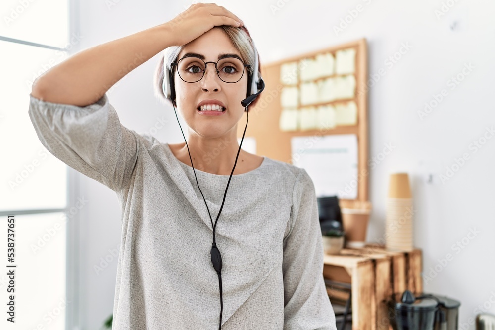 Sticker young beautiful woman working at the office wearing operator headset stressed and frustrated with ha