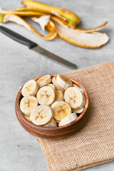 Fototapeta na wymiar Photo of banana slices in a bowl on a concrete surface