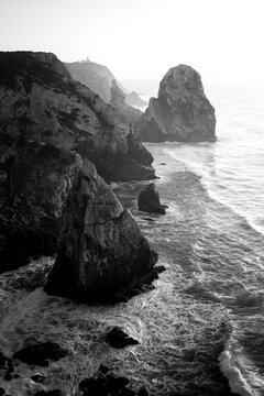 Rocks in Miradouro da Praia do Caneiro, the Atlantic, Portugal. Black and white photo.