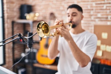 Obraz premium Young arab man musician playing trumpet at music studio