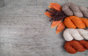 Fall colored yarn skeins on a wood table
