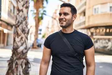 Young hispanic man smiling confident standing at street