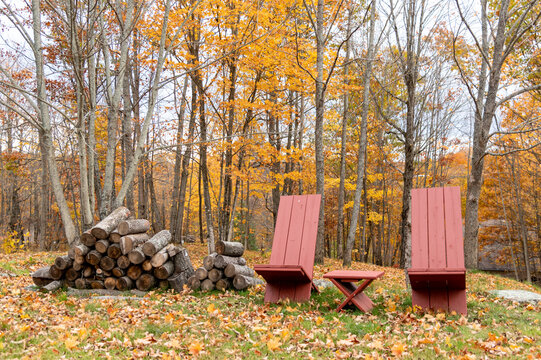 Fireside Chairs In A Fall Setting Beside A Wood Pile