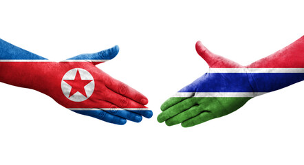 Handshake between Gambia and North Korea flags painted on hands, isolated transparent image.