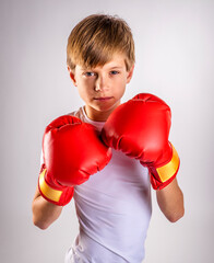 Male youth boxer boy with boxing gloves raised to defend his face