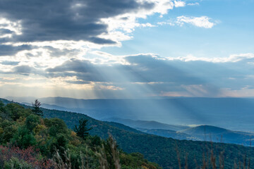 Rays of light can be seen shining through the clouds over the blue Ridge Mountains inside...