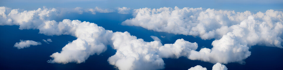 Beautiful aerial view of white clouds on a blue background. Flying above the clouds. Airplane view. Cumulus clouds. Flying high. super wide horizontal. Render


