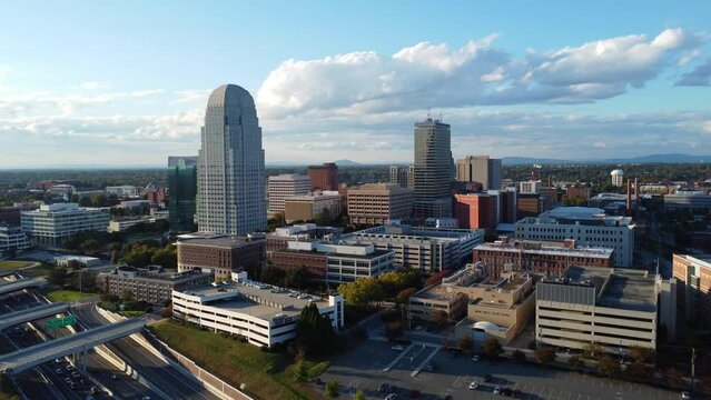 Reverse upward Aerial of downtown Winston-salem with business 40