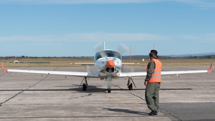 Mecanico aeronautico asistiendo en la puesta en marcha de un avion de entrenamiento