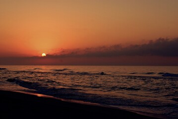 La playa al atardecer bañada con tonos de colores naranjas 