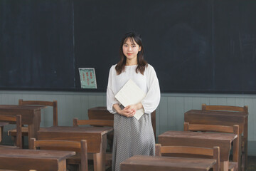 ノートを抱えて微笑む女性　School