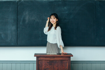 黒板の前で微笑む女性　student	