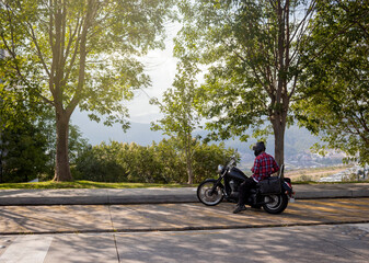 Man riding a motorcycle watching the landscape on the side of the road