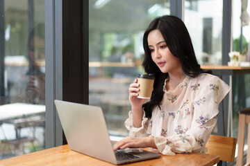 Fototapeta premium Businesswoman Working Alone On Laptop In Office Boardroom