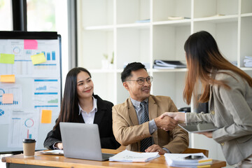 Group of young Asian business people or creative team in brainstorm discussion meeting in office.