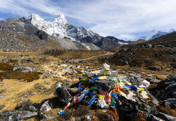 Ama Dablam peak and base camp in the Himalaya in Nepal with tibetan buddhist prayer flags.