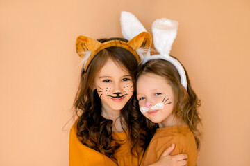 Children with painted faces in rabbit and tiger costumes are hugging and smiling sweetly. The old...