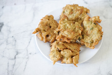Bakwan goreng, fried food, Indonesian traditional street food snacks. fried vegetables dough fritters, appetizer on a white plate