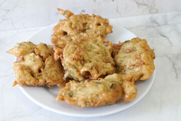 Bakwan goreng, fried food, Indonesian traditional street food snacks. fried vegetables dough fritters, appetizer on a white plate