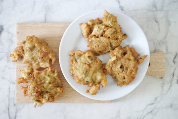 Bakwan goreng, fried food, Indonesian traditional street food snacks. fried vegetables dough fritters, appetizer on a white plate