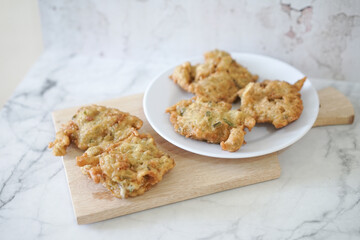 Bakwan goreng, fried food, Indonesian traditional street food snacks. fried vegetables dough fritters, appetizer on a white plate