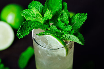 mojito cocktail top view with lime and mint leaves on a wooden table, refreshing cold drink with rum