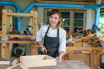 portrait of beautiful asian woman carpenter dealing with handicraft, woman has own business...