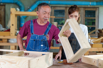 Tutor With Female Carpentry Student In Workshop Studying For Apprenticeship At College ,Teacher explaining a structure students while standing in a woodwork class