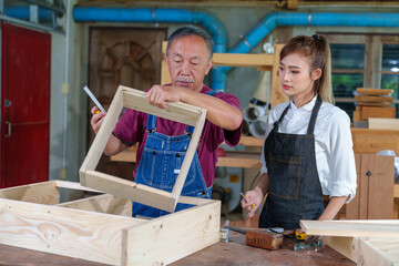Tutor With Female Carpentry Student In Workshop Studying For Apprenticeship At College ,Teacher...