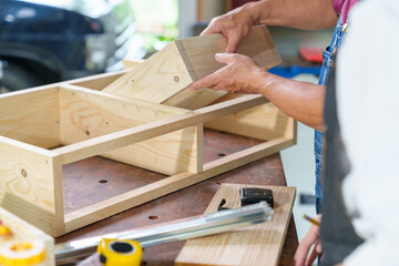 Tutor With Female Carpentry Student In Workshop Studying For Apprenticeship At College ,Teacher explaining a structure students while standing in a woodwork class