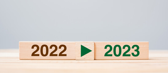 2023 and 2022 wooden block on table background. Resolution, strategy, countdown, goal, change and...