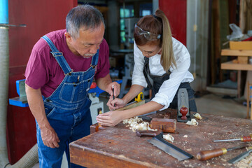 Tutor With Female Carpentry Student In Workshop Studying For Apprenticeship At College ,Teacher explaining a structure students while standing in a woodwork class