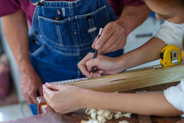 Tutor With Female Carpentry Student In Workshop Studying For Apprenticeship At College ,Teacher explaining a structure students while standing in a woodwork class